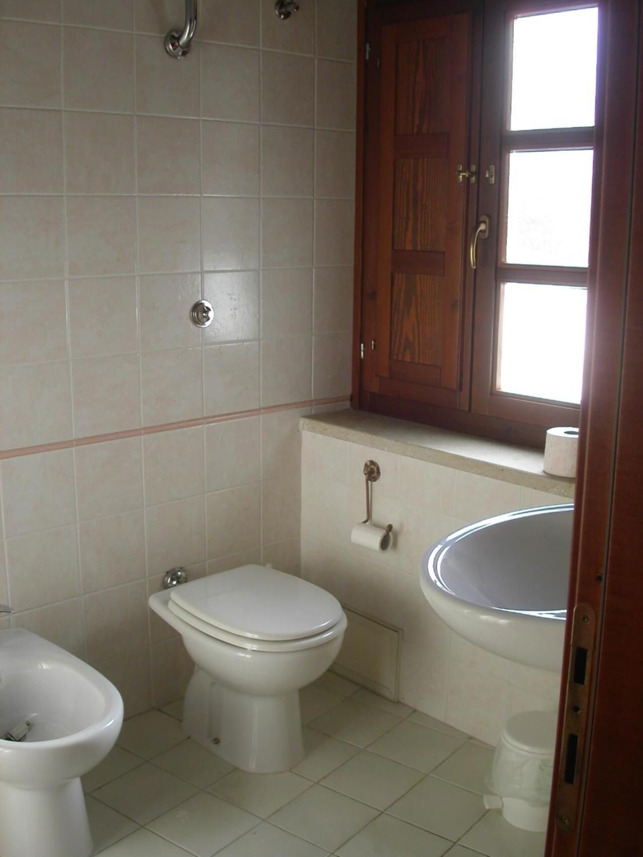 Un baño con inodoro, bidé y lavamanos.