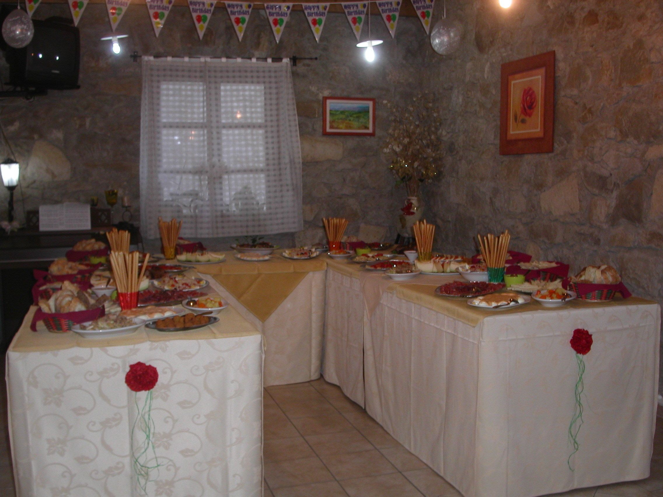 Ein reichhaltiges Buffet mit mehreren Tischen, die mit Tischdecken bedeckt sind, mit verschiedenen Speisen und Dekorationen.