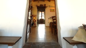 A rustic interior with a stone archway leading to a hallway. - Locanda La Rosa (Pauli Arbarei)