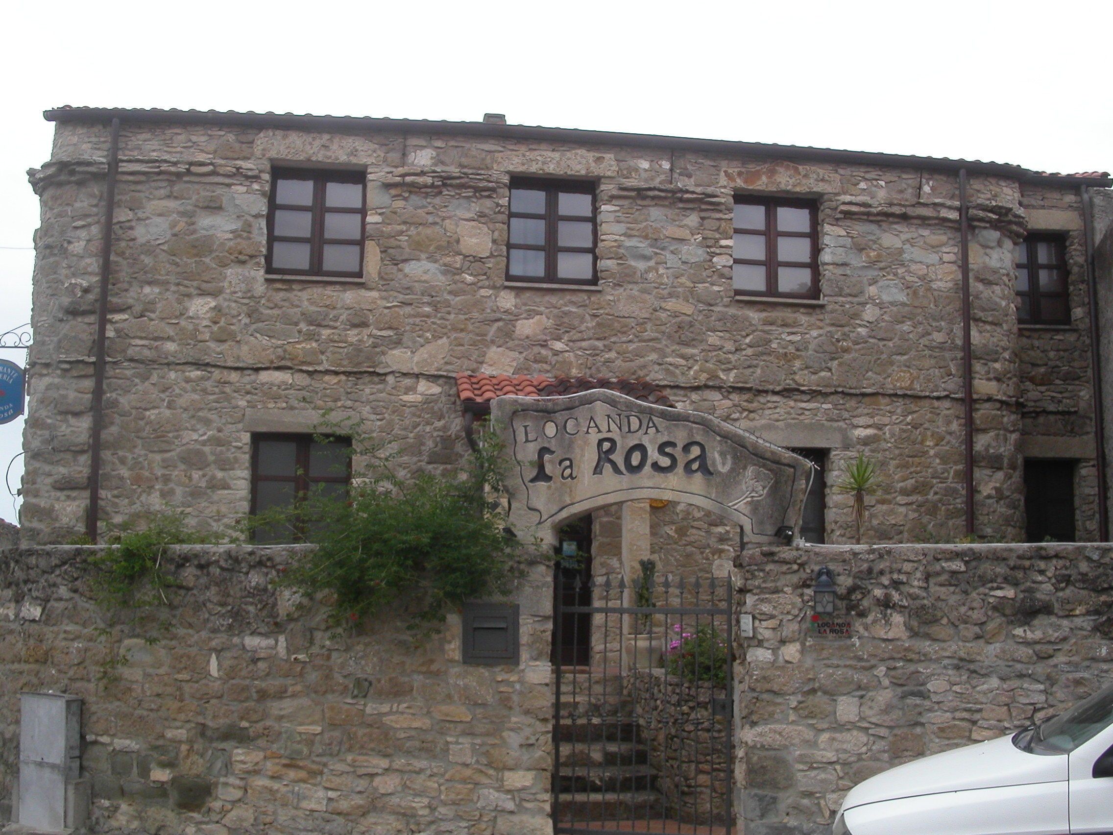 Un bâtiment en pierre sur lequel on peut lire l’inscription « Locanda La Rosa ».
