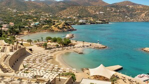 Une station balnéaire dotée d’un espace de détente en bord de mer, d’une piscine et offrant une vue sur la mer et les montagnes.