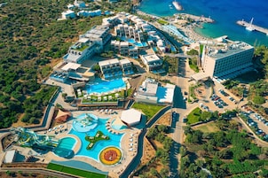 Un resort con varias piscinas, un parque acuático y una zona de playa.