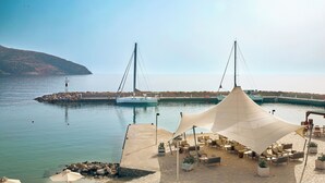 Une terrasse au bord de l’eau, dotée de sièges extérieurs et d’un grand auvent.