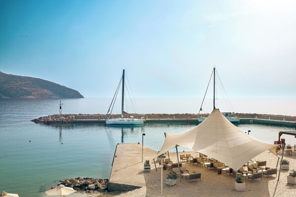 A waterfront patio with outdoor seating and a large canopy.