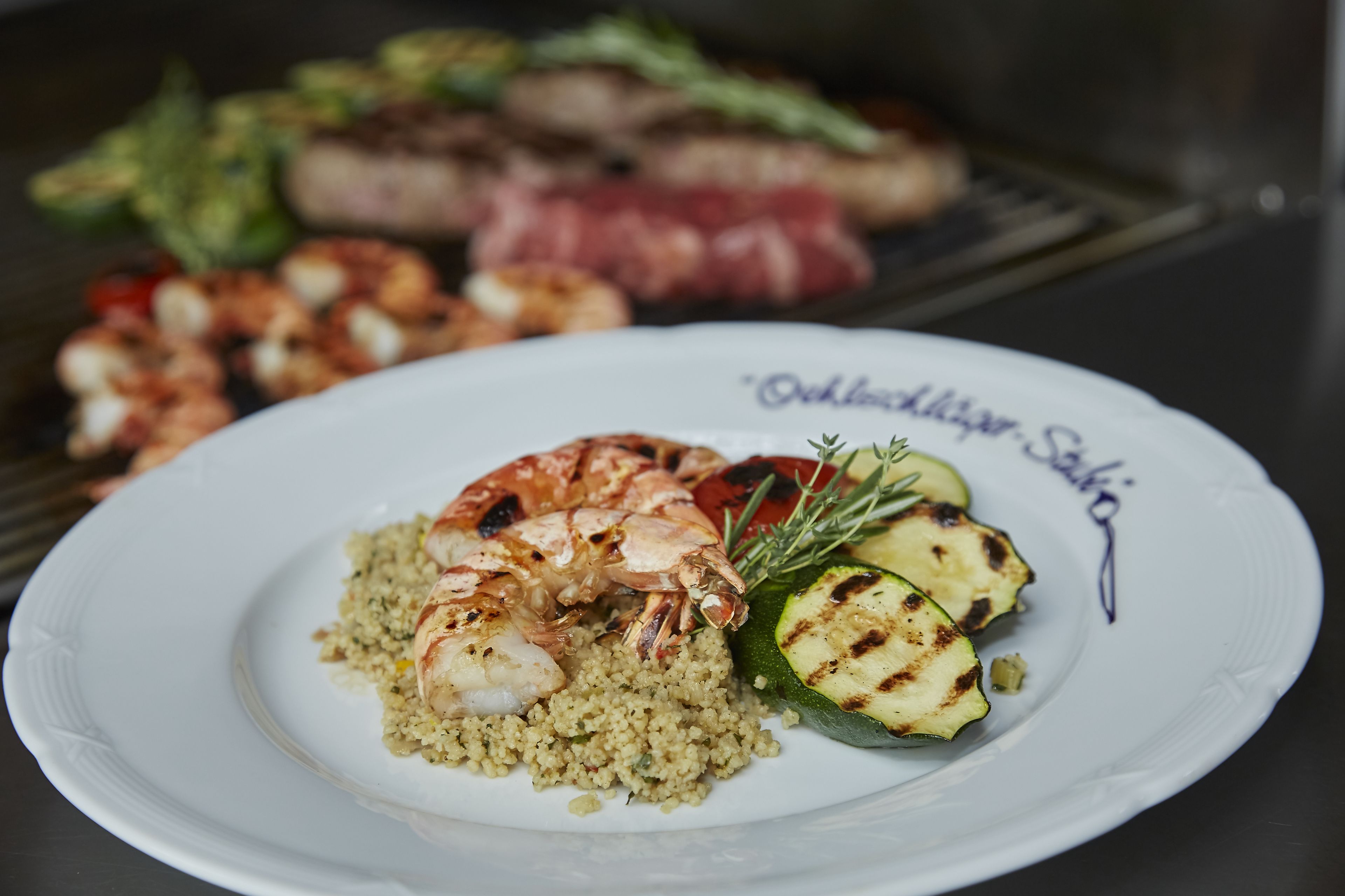 Ein Teller mit gegrillten Garnelen, Quinoa und gegrilltem Zucchini.