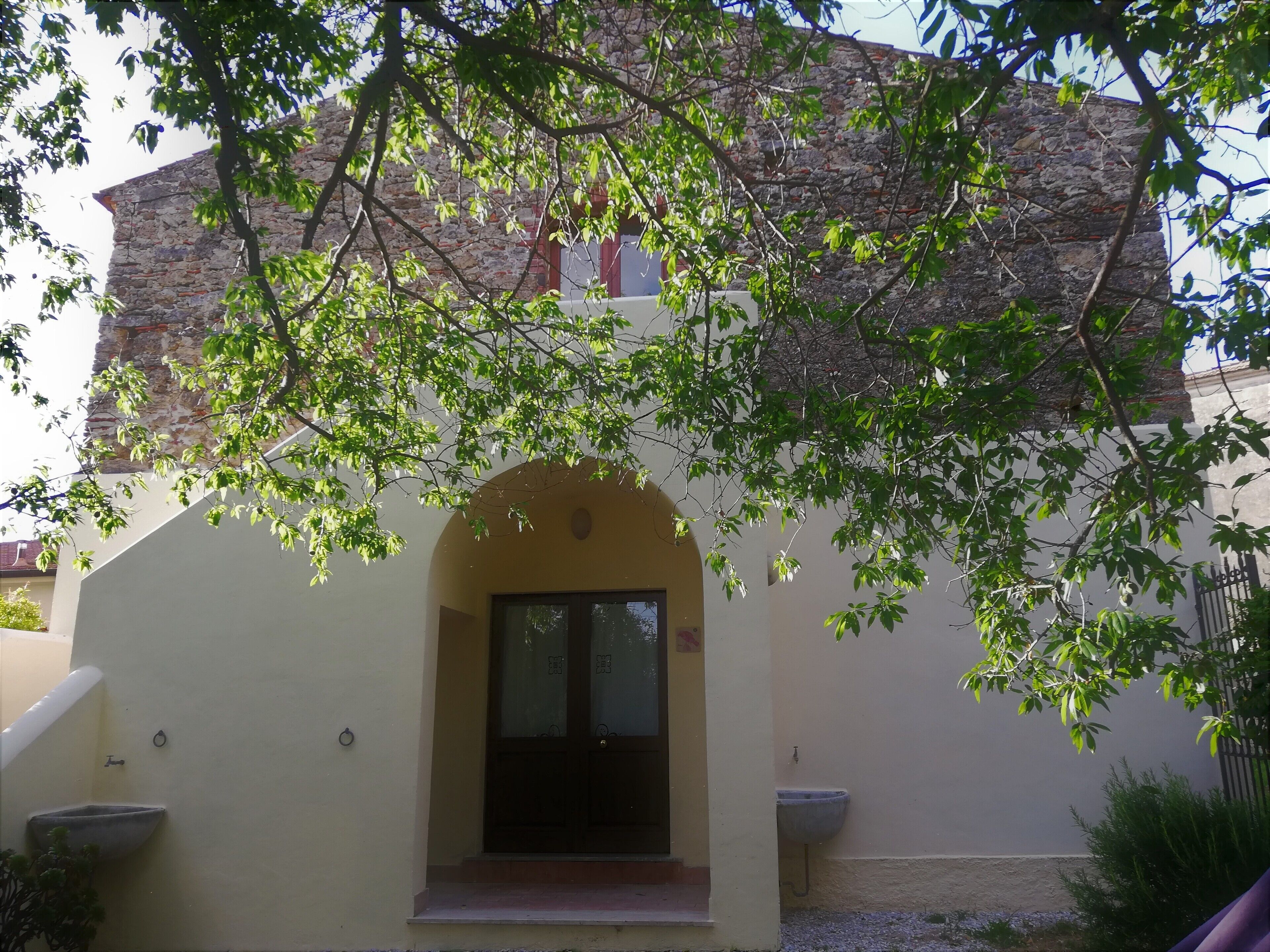 A building with a stone facade, a yellow entrance, and a window with a door.