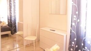 A bedroom with a bed, a chair, a desk, and a mirror. - B&B Italia (Milis)