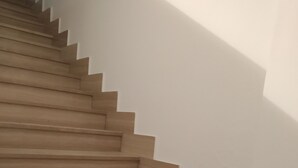 A staircase with wooden steps and white walls. - B&B Italia (Milis)
