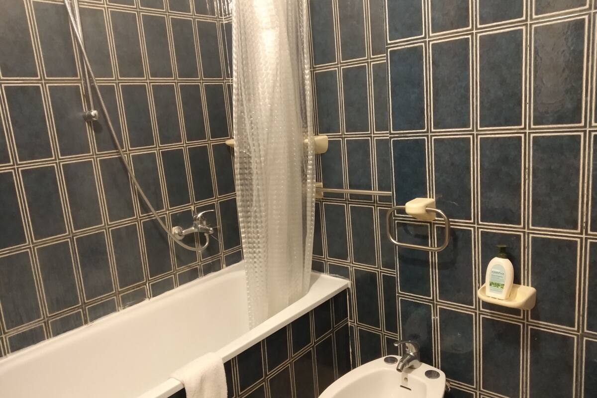 A bathroom with a bathtub, a shower, and a sink.