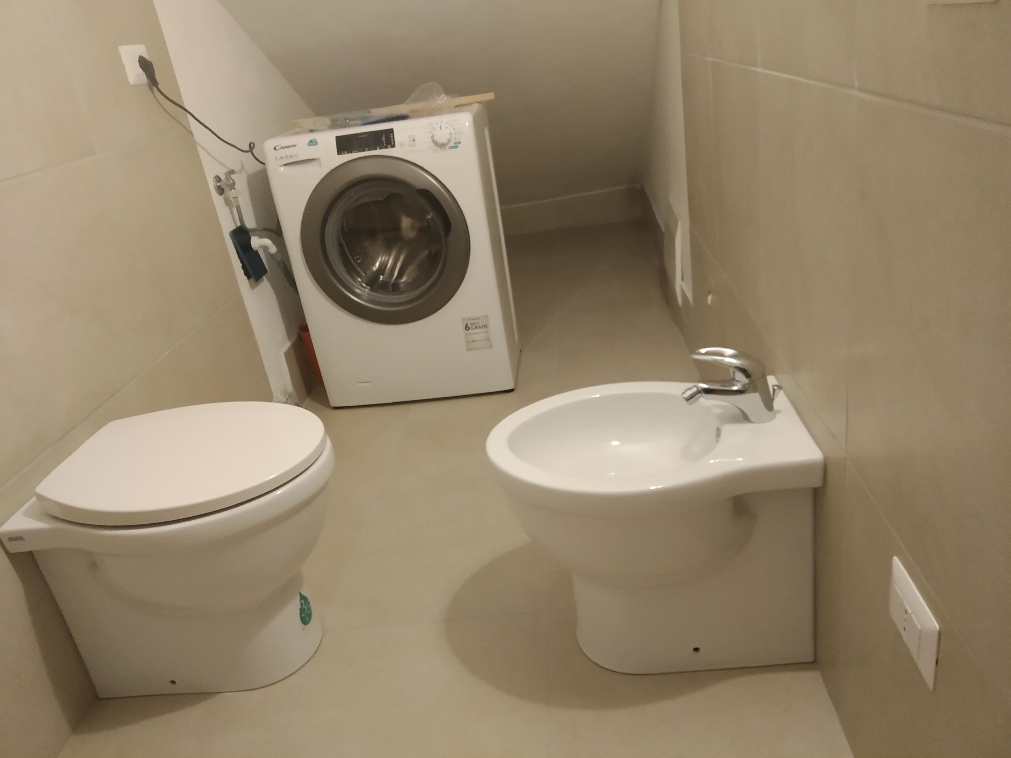 Ein Badezimmer mit Toilette, Bidet und Waschmaschine.