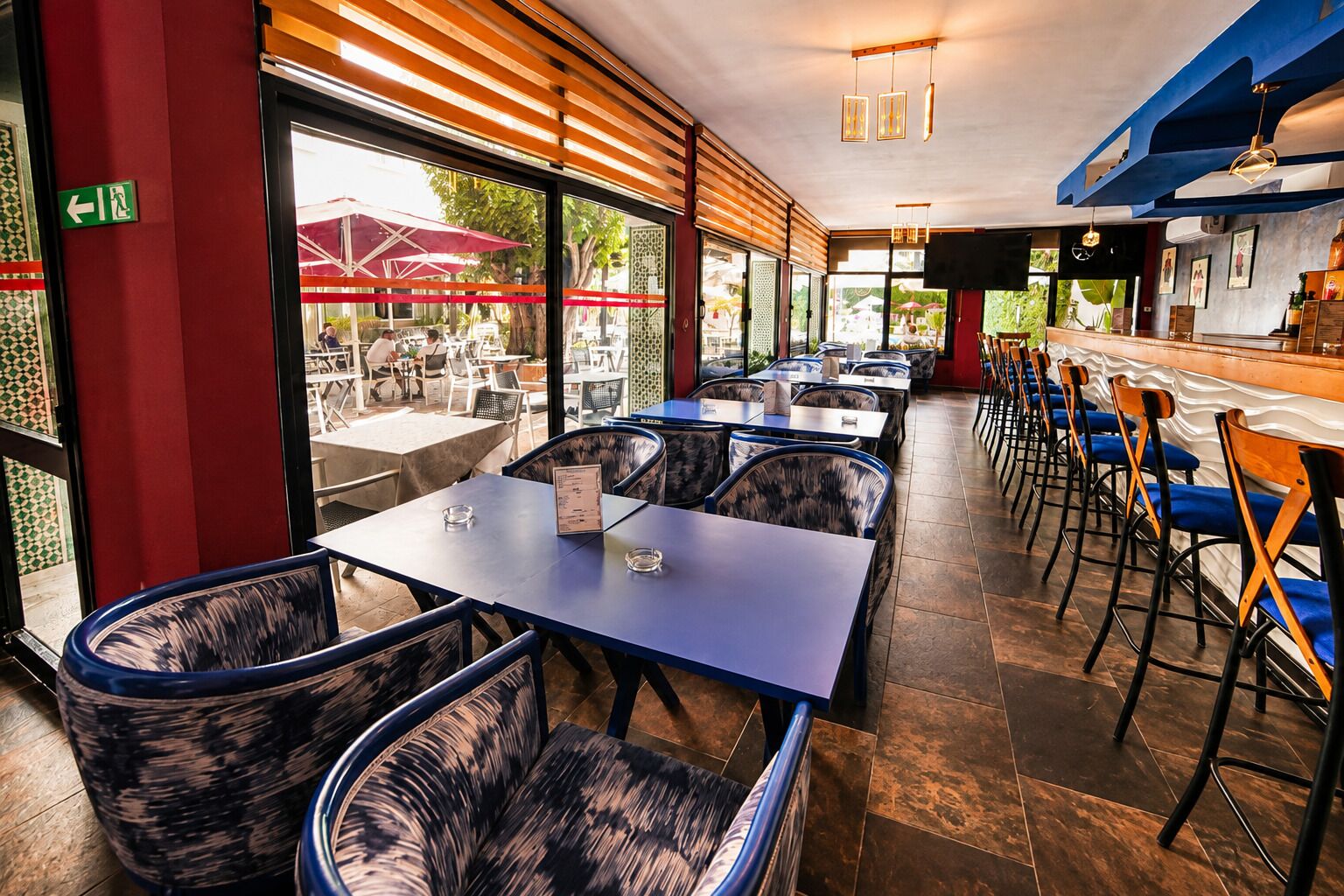 Un ristorante con posti a sedere interni, un'area bar e ampie finestre che offrono vista sulla zona all'aperto.