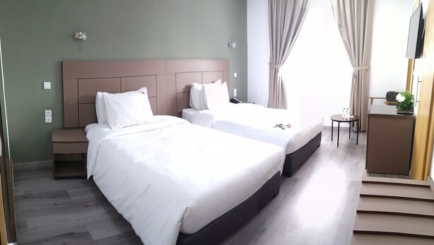 A hotel room with two beds, a desk, a chair, and a TV. - Hotel Mamora (Kenitra)