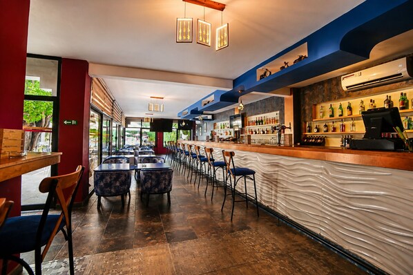 Un espace bar avec un comptoir, des sièges et une vue sur l’extérieur.