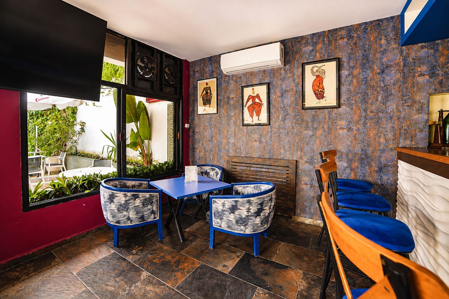 A dining area with a table and chairs, a counter, and artwork on the walls.