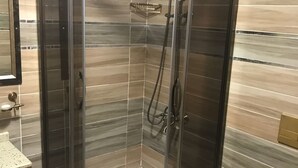 A modern bathroom with a glass-enclosed shower, a toilet, and a sink. - Ozcelik Hotel (Salihli)