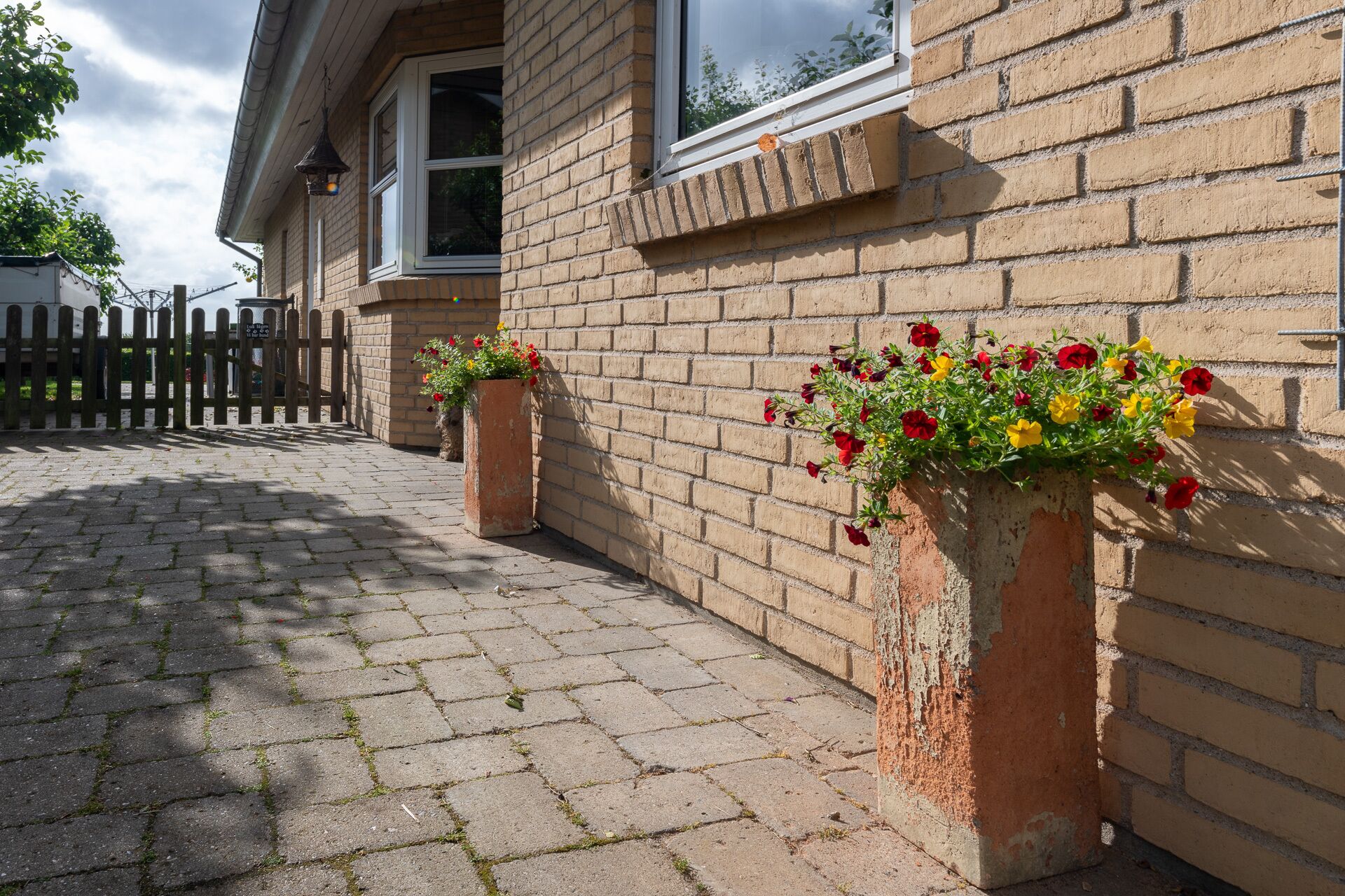 Un bâtiment en briques avec des jardinières au niveau du rez-de-chaussée.