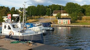 Un puerto tranquilo con barcos amarrados, un edificio pequeño y un banco junto al agua.