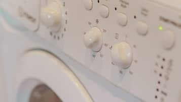A front view of a white washing machine with control knobs and settings.