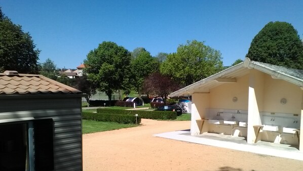 A small, single-story building with a covered outdoor seating area and a small pool. - Camping Le Verdillé (Saint-Just-en-Chevalet)