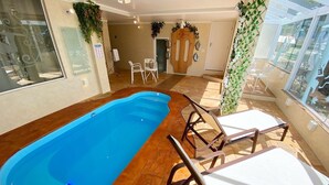 A swimming pool with lounge chairs and a door with a nameplate.