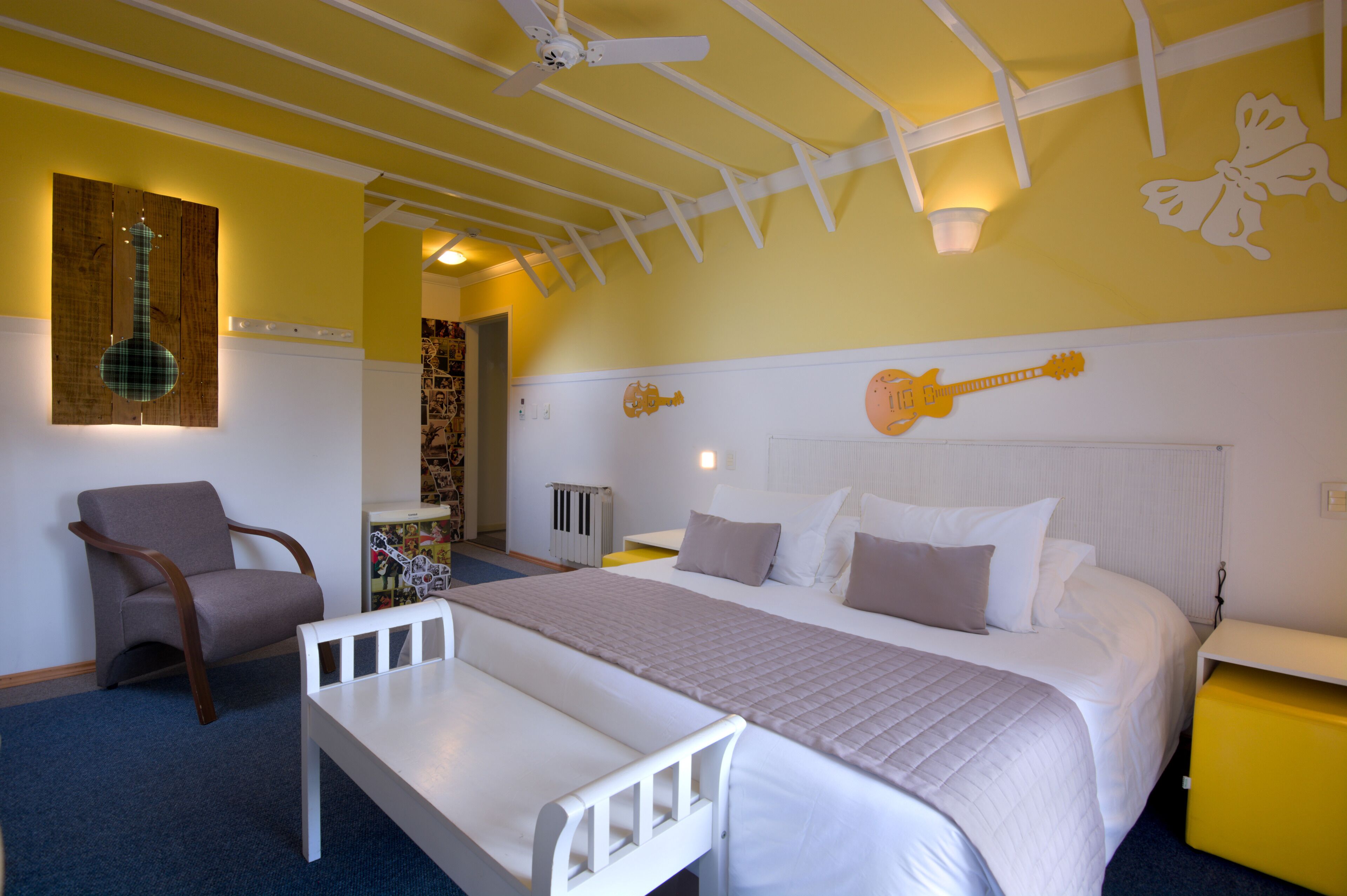 Une chambre à coucher avec un lit, une chaise, une table et un ventilateur de plafond.
