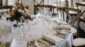 Comedor con papel tapiz decorado, candelabros y centros de mesa florales.