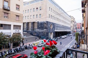 Vista de la calle con un edificio que dice "OVS" y una fila de scooters estacionados.