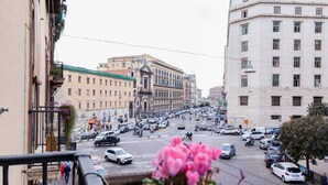 A street view with buildings, cars, and a pedestrian. - Monteoliveto 33 (Naples)