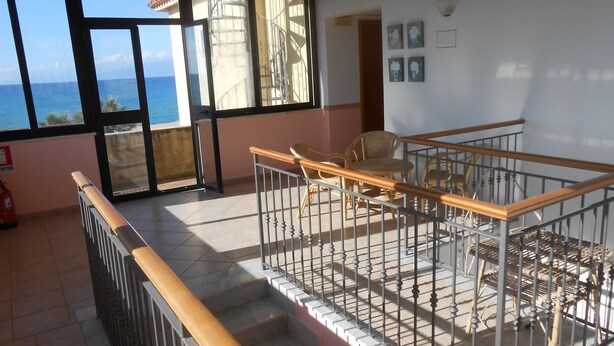 A balcony with a view of the sea, a fire extinguisher, and a staircase. - Terrazzino (Vibo Valentia)
