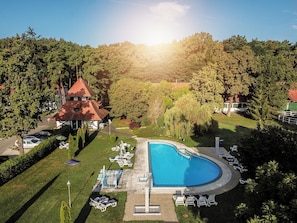 A swimming pool with lounge chairs, a gazebo, and a forested area. - Abbázia Country Club (Márokföld)