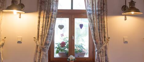 A room with a window, curtains, and wall-mounted lights.