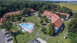 An aerial view of a resort with a swimming pool, multiple buildings, and a parking area. - Abbázia Country Club (Márokföld)