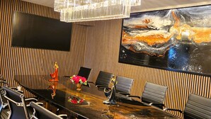 A conference room with a large painting, a chandelier, and modern chairs. - Vänerport Lakefront (Mariestad)