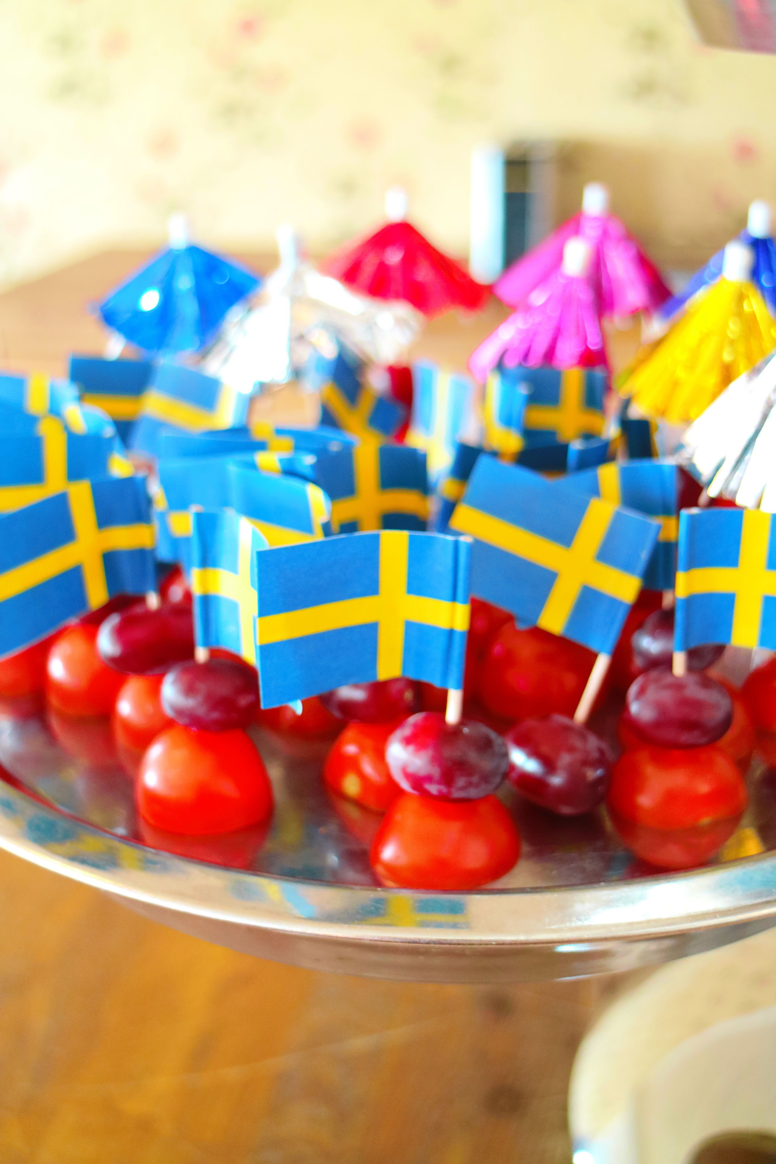 A tray of Swedish flag-shaped treats on red cherries.