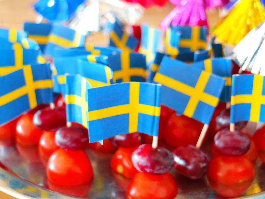 A tray of Swedish flag-shaped treats on red cherries.