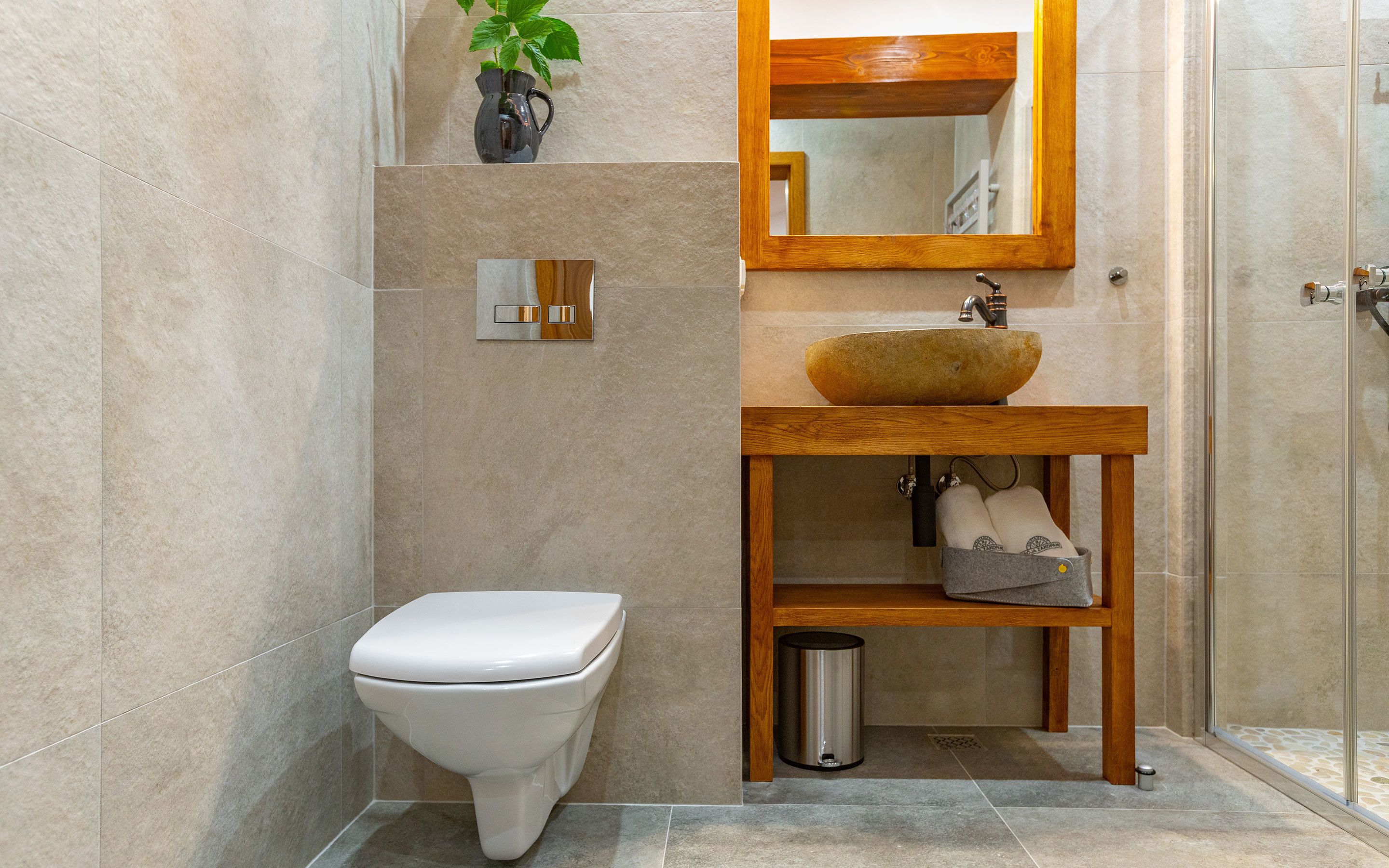 A modern bathroom with a toilet, sink, and shower.