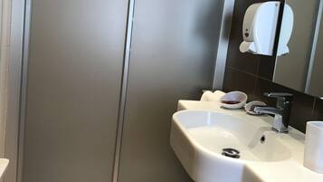 Un baño moderno con un espejo grande, un lavabo blanco y un inodoro.