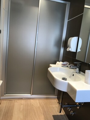 A modern bathroom with a large mirror, a white sink, and a toilet. - Hostal Cafe Gutgreco (Sonseca)