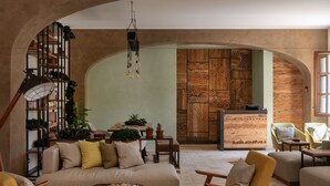 Una sala de estar acogedora con un sofá, sillones, una mesa de centro y una estantería llena de plantas.
