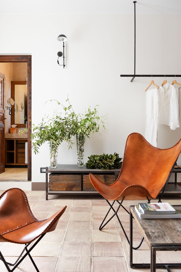 A modern living room with a brown leather chair, a wooden coffee table, and a console table with plants.