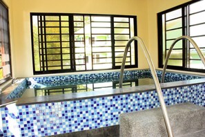 A swimming pool with blue mosaic tiles, metal handrails, and a view through black-framed windows. - Dureme Mansion Hotel and Resort (Castillejos)