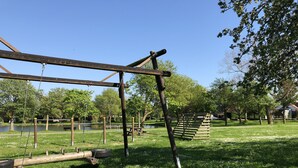 A park with a swing set, a wooden ladder, and a picnic table.