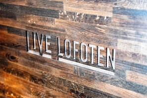 A wooden wall with the text "LIVE LOFOTEN" carved into it. - Live Lofoten Hotel (Vestvågøy)