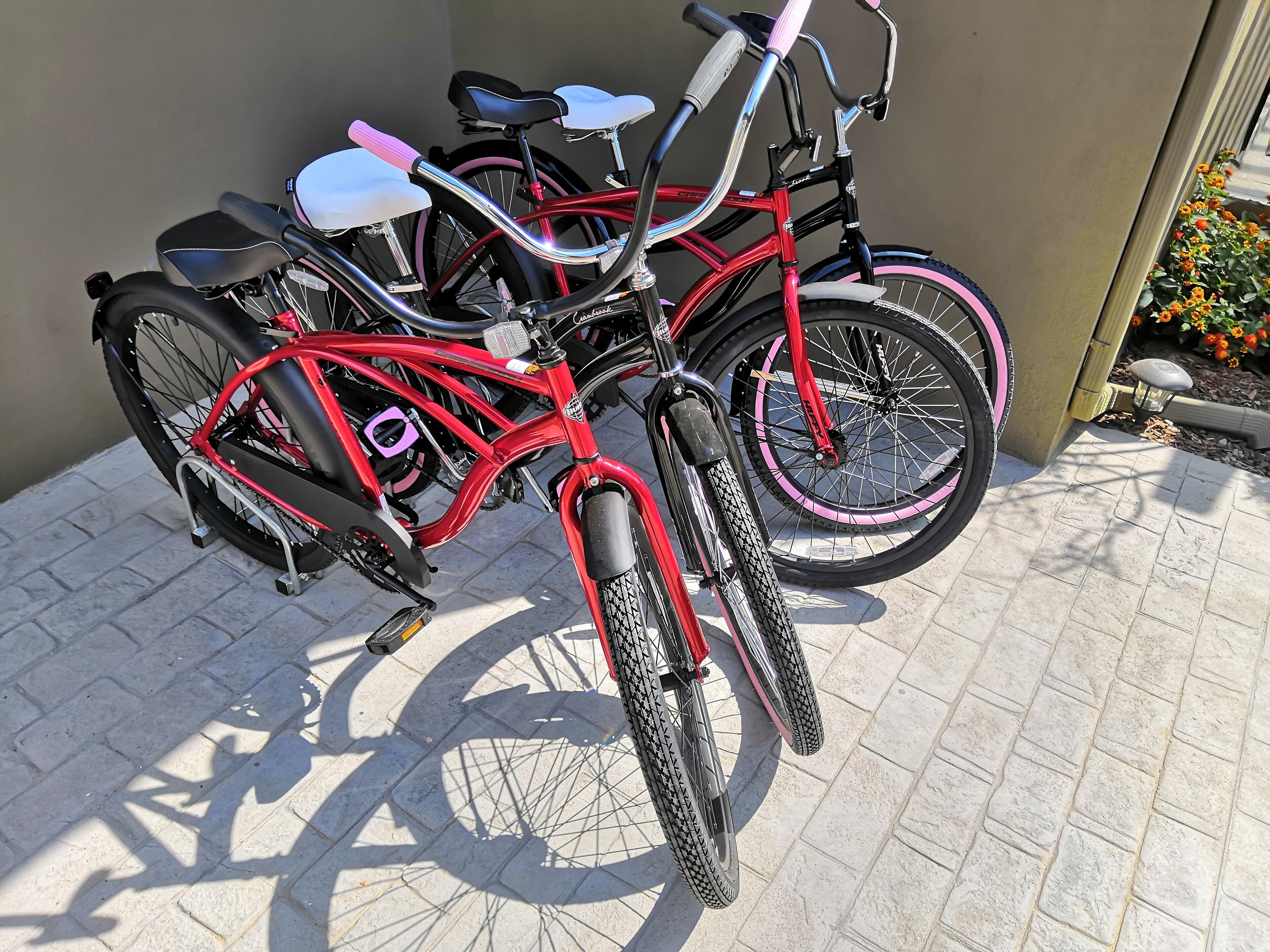 A bicycle with a red frame and black tires parked against a wall.