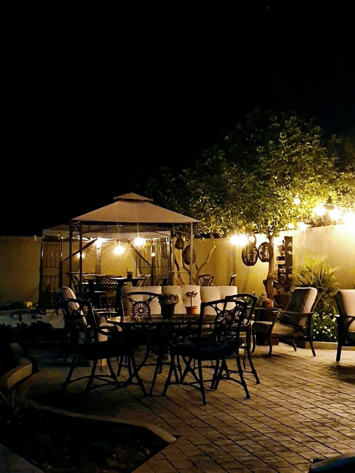 Eine Außenpatio-Terrasse mit überdachter Sitzgelegenheit, Tischen und Stühlen.