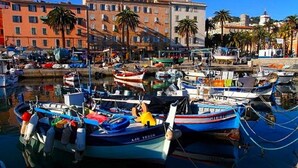 A marina with boats docked, surrounded by buildings and palm trees. - Magnificent T2 on the ground floor with pool in Alata in southern Corsica (Alata)