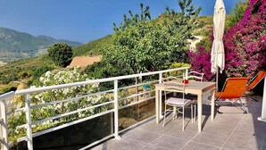 A terrace with a table and chairs, a white railing, and a view of the countryside. - Magnificent T2 on the ground floor with pool in Alata in southern Corsica (Alata)