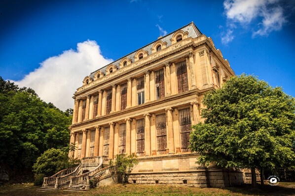 A large, historic building with classical architecture, featuring a central staircase and columns. - Magnificent T2 on the ground floor with pool in Alata in southern Corsica (Alata)