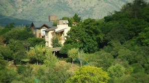 A house surrounded by dense greenery and hills. - Cabañas El Dominador (La Falda)
