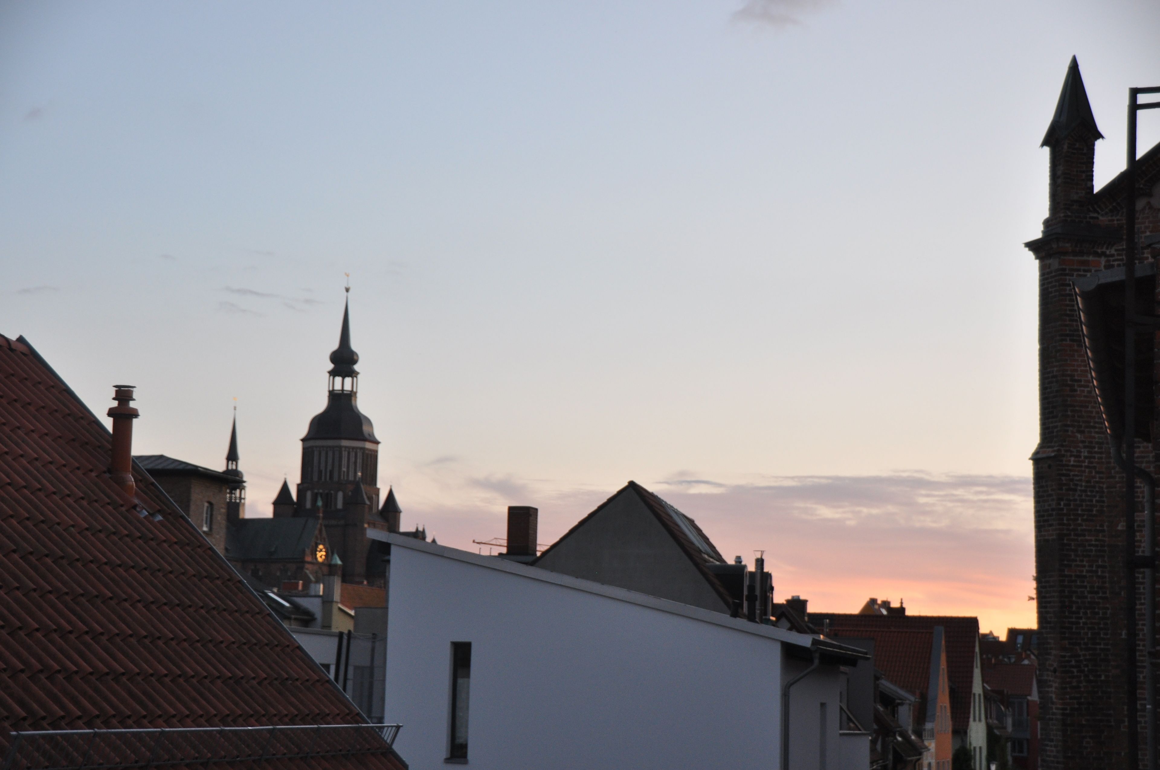 A cityscape with a prominent church tower and adjacent buildings.